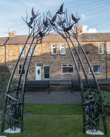 Iron sculpture: arch of trees with birds